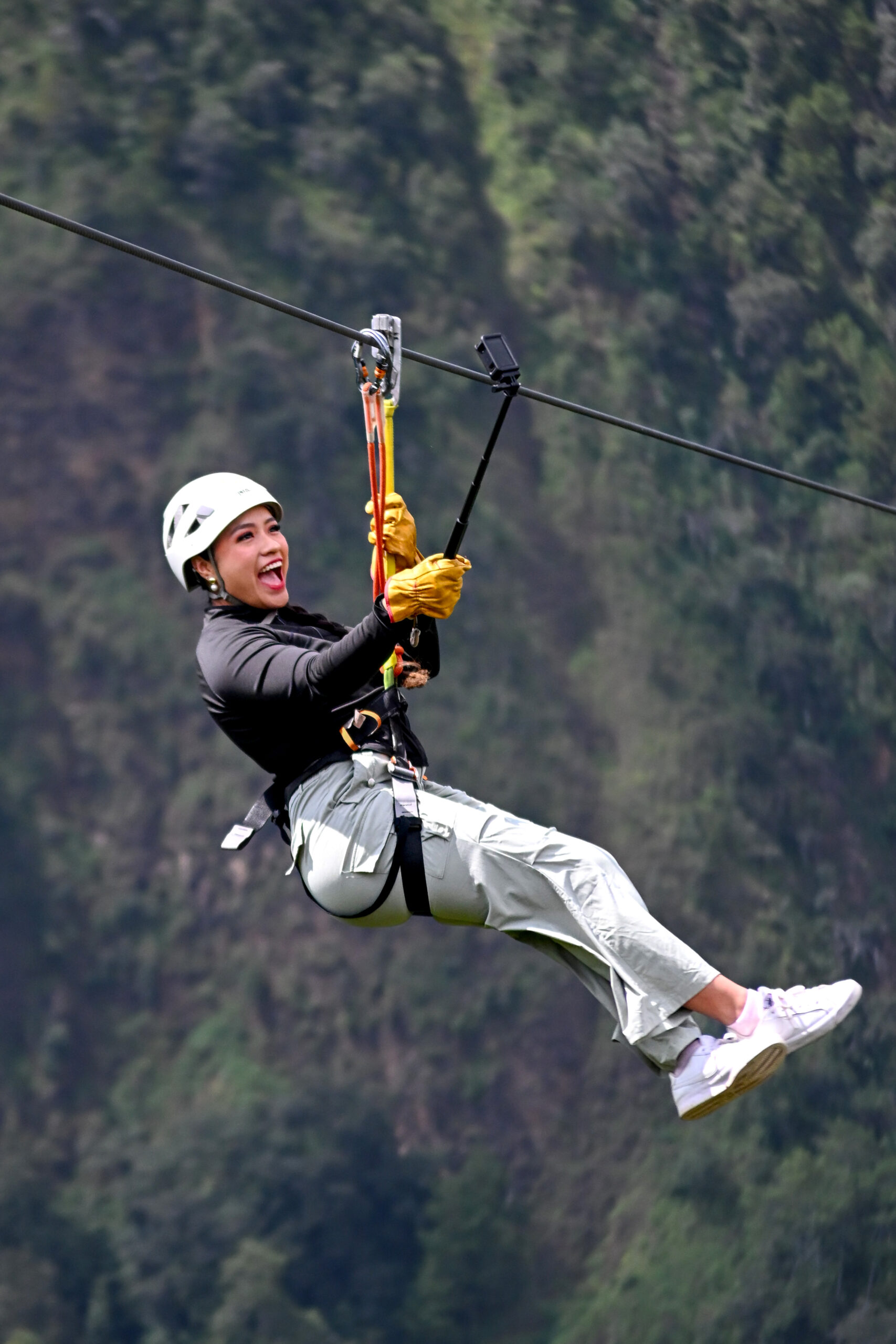 Visitante sonriente grabando su vuelo con cámara en bastón